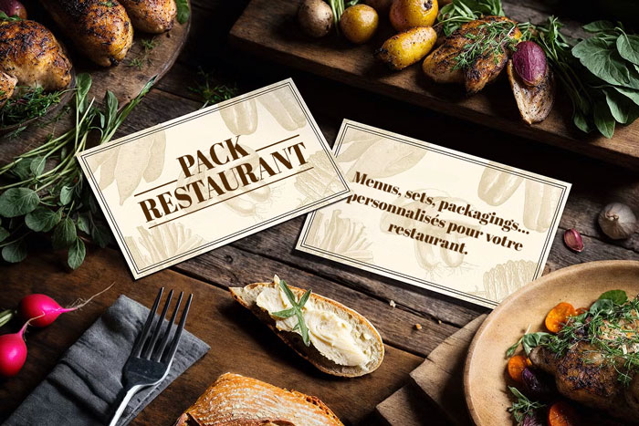 Visuel du pack restaurant personnalisable sur une table, avec cartes « PACK RESTAURANTS » – Menus, sets, packagings personnalisés.